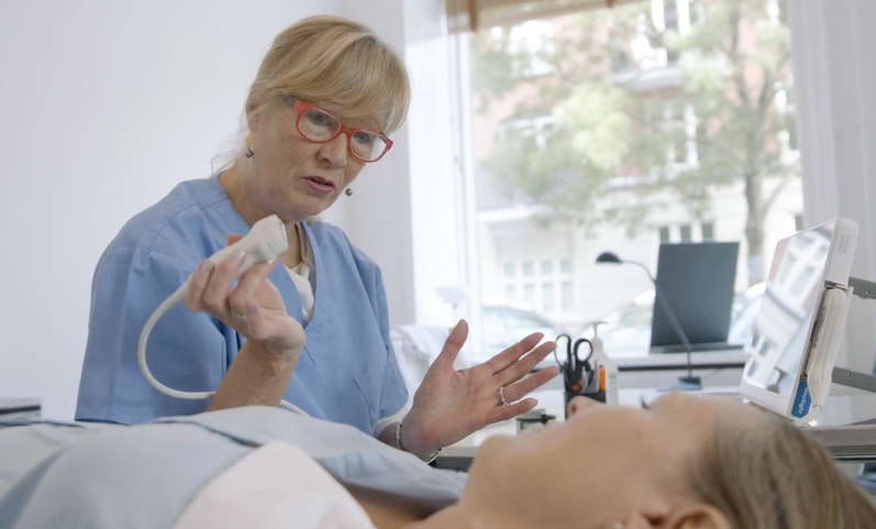 Sygeplejerske taler med en patient under et sundhedstjek for åreforkalkning