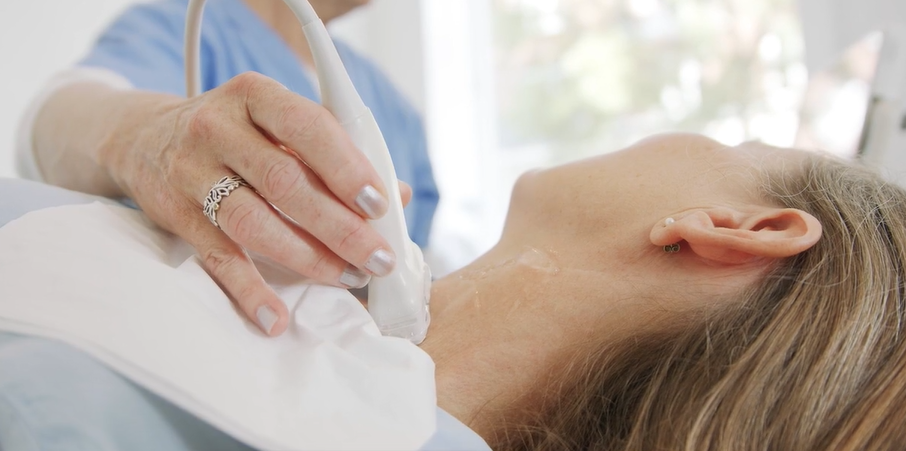 Sygeplejerske bruger ultralydsscanner på patientens hals for at tjekke for åreforkalkning
