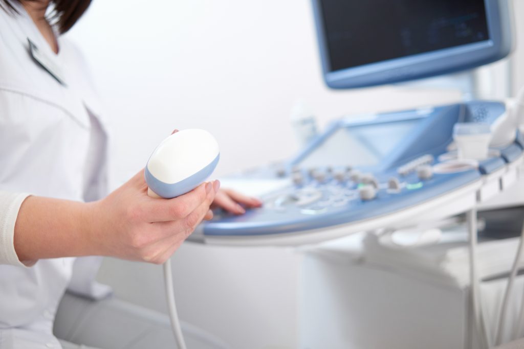 Sygeplejerske holder en scanner i hånden under en ultralydsscanning af hjertet