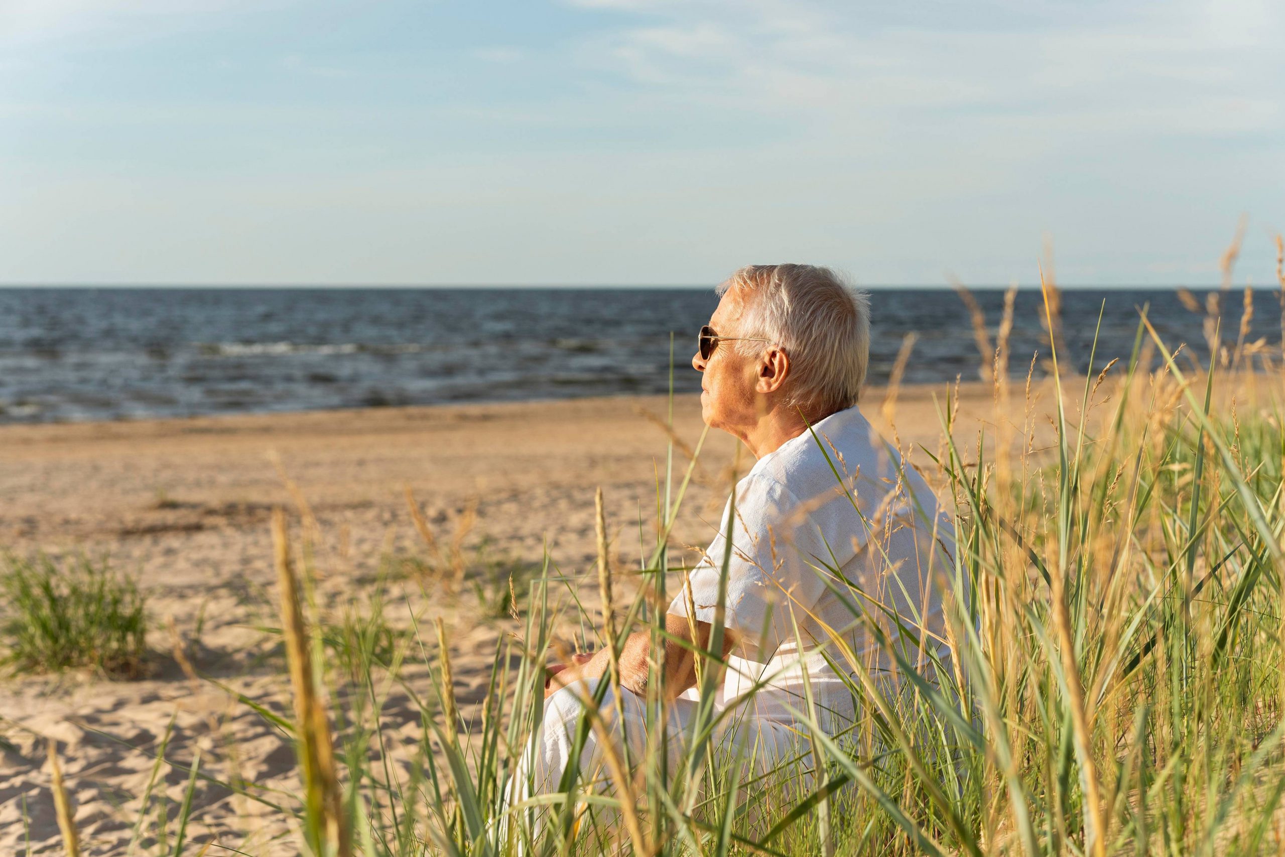 side-view-older-man-enjoying-his-time-by-beach_11zon Helbredstjek 60 år: Portræt af en kvinde i hendes 60'ere, der står og holder en kop kaffe